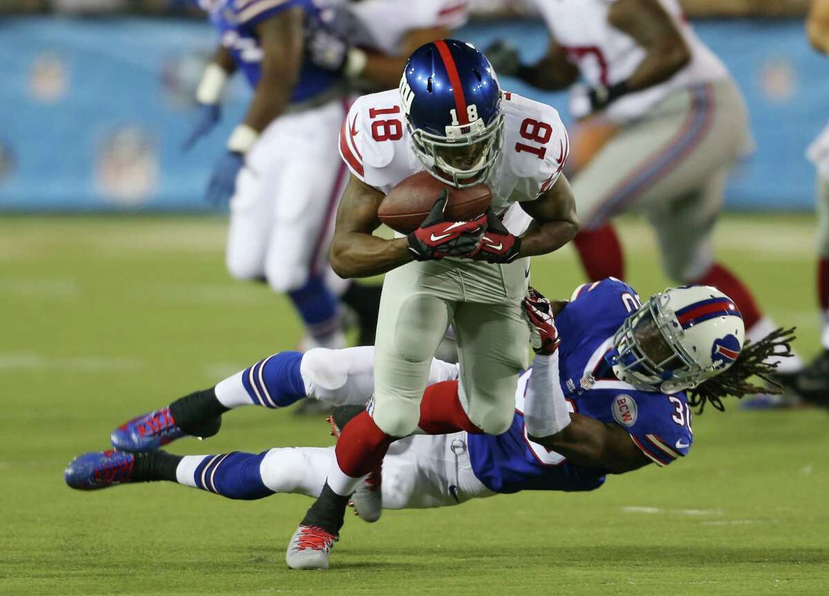 Giants receiver Marcus Harris (18) tries to break free while taking the Bills' Mario Butler for a ride.