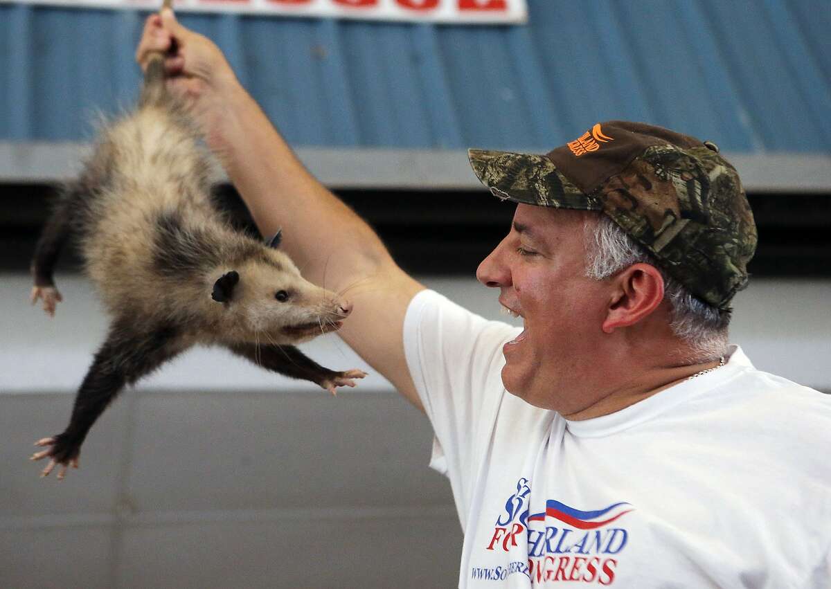 U.S. Rep Steve Southerland grins after winning an auctioned possum during the Wausau Possum Festival on Saturday, Aug. 2, 2014, in Wausau, Fla. What is usually a must-attend event for statewide candidates was notably lacking of them this year, perhaps because candidates who now raise tens of millions of dollars focus more on television ads than making personal contact. But not attending is a missed opportunity, said Susan MacManus, a University of South Florida political science professor who drove more than 350 miles for the festival. (AP Photo/The News Herald, Heather Leiphart)