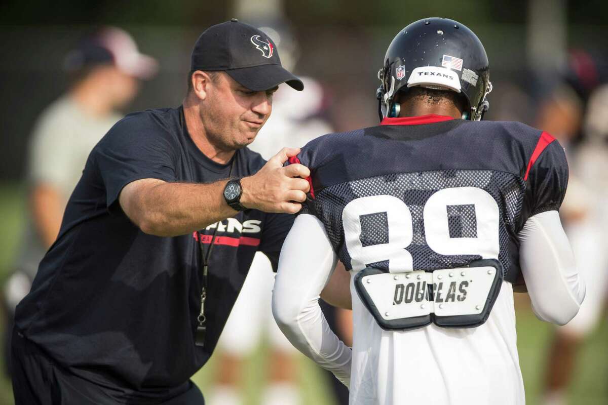 Texans coach Bill O'Brien, left, works in a little hands-on training with receiver Mike Thomas (89) during training camp. O'Brien is seeing more of Thomas because of Andre Johnson's injury.