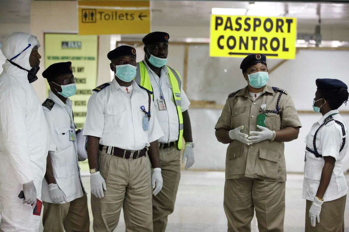 Nigeria health officials wait to screen passengers at the arrival hall of Murtala Muhammed International Airport in Lagos, Nigeria, Monday, Aug. 4, 2014. Nigerian authorities on Monday confirmed a second case of Ebola in Africa's most populous country, an alarming setback as officials across the region battle to stop the spread of a disease that has killed more than 700 people. (AP Photo/Sunday Alamba)