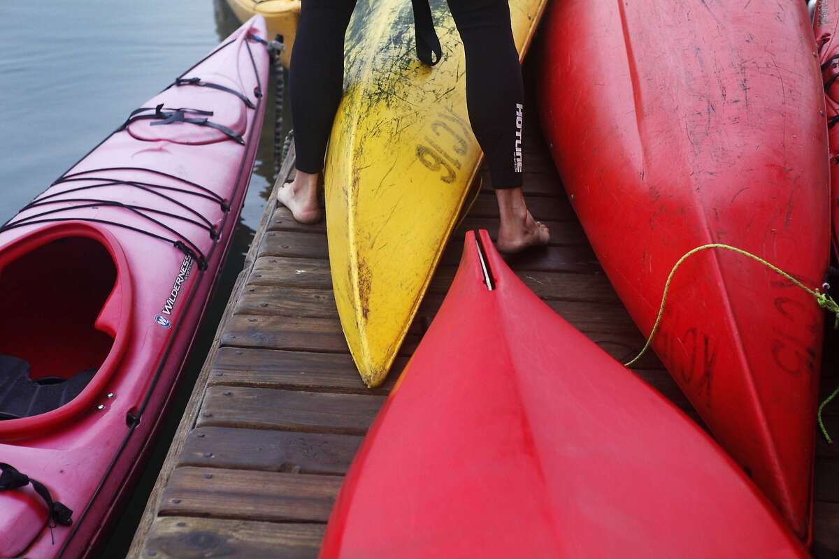 Dave Grigsby, owner of Kayak Connection, steps in between kayaks while preparing for a whale-watching expedition at the Elkhorn Yacht Club marina on July 30, 2014 in Moss Landing, Calif.