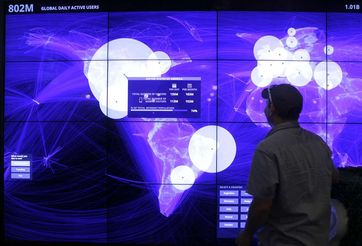 Eric Vaughn views a large monitor displaying real-time data of Facebook users worldwide at a conference for small business owners at Facebook's headquarters in Menlo Park, Calif. on Tuesday, Aug. 5, 2014. The Facebook Fit bootcamp at the social network's campus capped a five-city tour designed to help small businesses maximize their opportunities on the web.