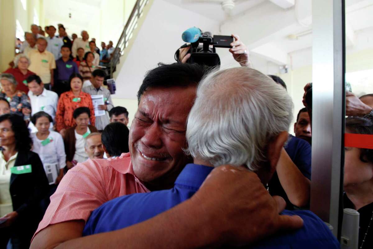 Cambodian former Khmer Rouge servitors, Soum Rithy, left, and Chum Mey, right, embrace each other after the verdicts were announced, at the U.N.-backed war crimes tribunal in Phnom Penh, Cambodia, Thurdday, Aug. 7, 2014. Three and a half decades after the genocidal rule of Cambodia's Khmer Rouge ended, the tribunal on Thursday sentenced two top leaders of the former regime to life in prison on war crimes charges for their role in the country's terror period in the 1970s. (AP Photo/Heng Sinith)