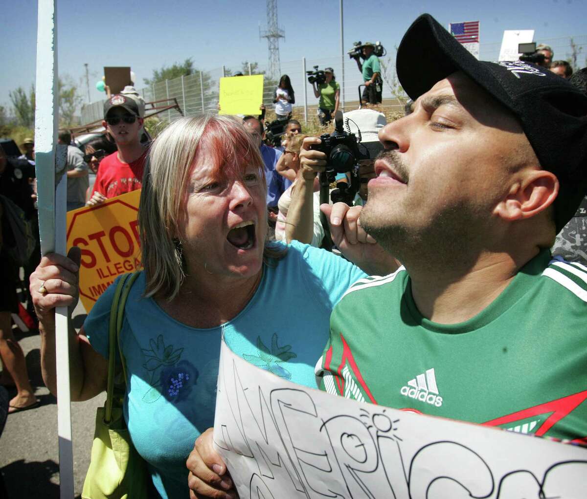 An unidentified protester (left) shouts at Lupillo Rivera, an American, as buses carrying immigrants attempt to enter Murrieta, Calif. Will she eventually apologize?