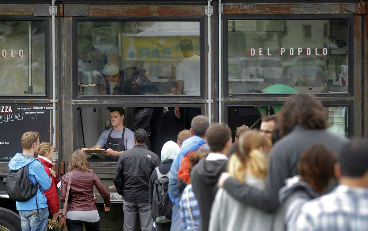 People line up at Del Popolo Pizza food truck during Off the Grid's Sunday Picnic in the Presidio Main Post lawn in San Francisco, Calif., on Sunday, August 3, 2014. It is a gathering of food trucks with food stalls and even some produce markets that showcases the best of street food gatherings: the beer and wine, the crowds of all ages, the lawn, and lots and lots of food.