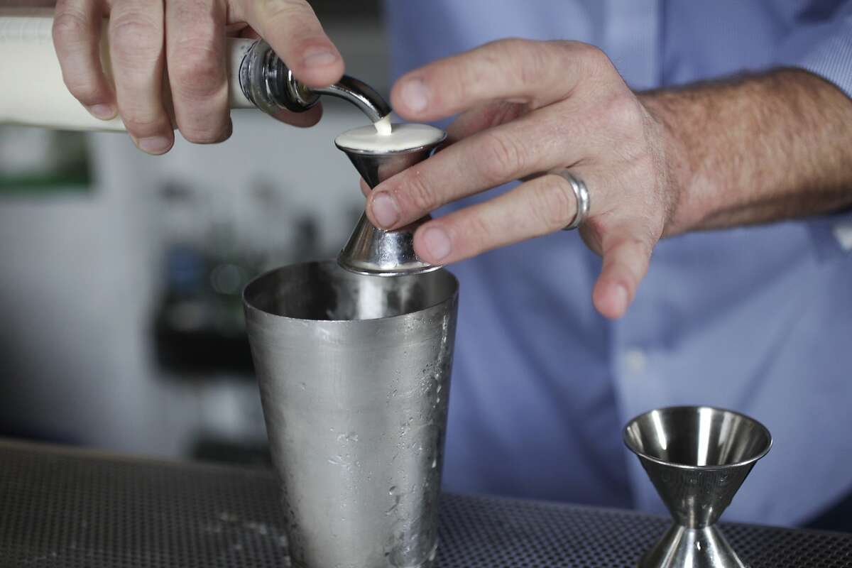 Hard Water Bar Manager Erik Adkins measures out .5oz of Straus heavy cream to pour into a shaker cup as he prepares the "Bourbon Lift", a drink featured on the menu at Hard Water August 5, 2014 at Hard Water in San Francisco, Calif.