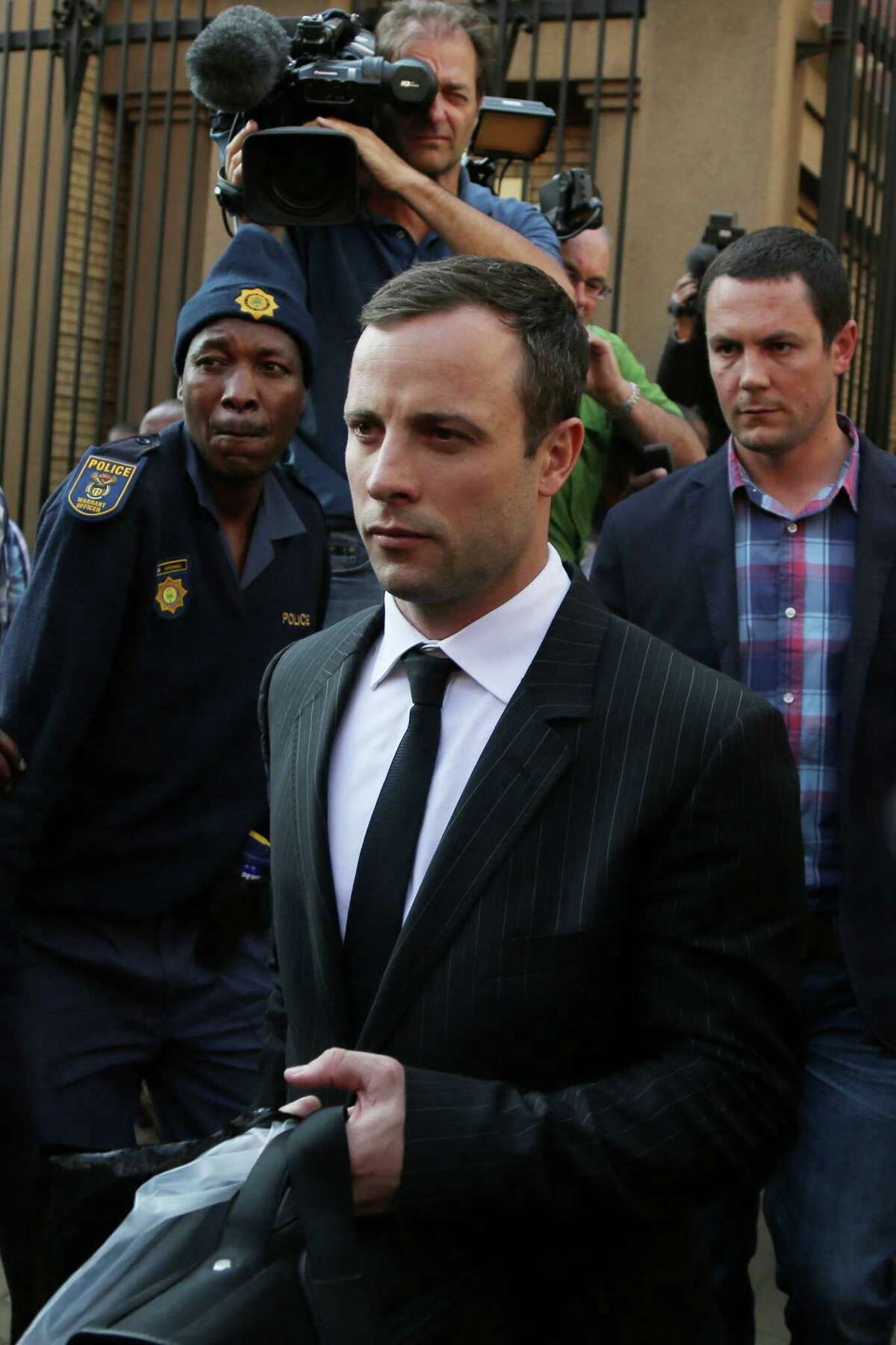 Oscar Pistorius leaves the high court in Pretoria, South Africa, Friday, Aug. 8, 2014. The judge in the murder trial of Oscar Pistorius says she will give a verdict on Sept. 11. (AP Photo/Themba Hadebe)
