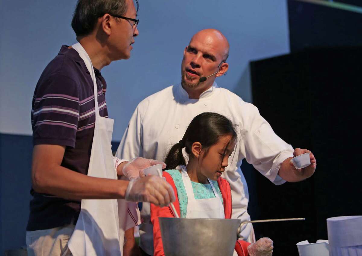 David Lin, left, with daughter Kaydence Lin, 10, with celebrity chef Shane Miller, preparing the Universe Breakfast Plate, at the Mars Food Face-Off at Space City Houston Saturday, Aug. 9, 2014, in Houston, Texas. Contestants, assisted by professional chefs, used authentic ingredients viable for a Mars mission, judged on creativity, presentation, nutritional value and taste.