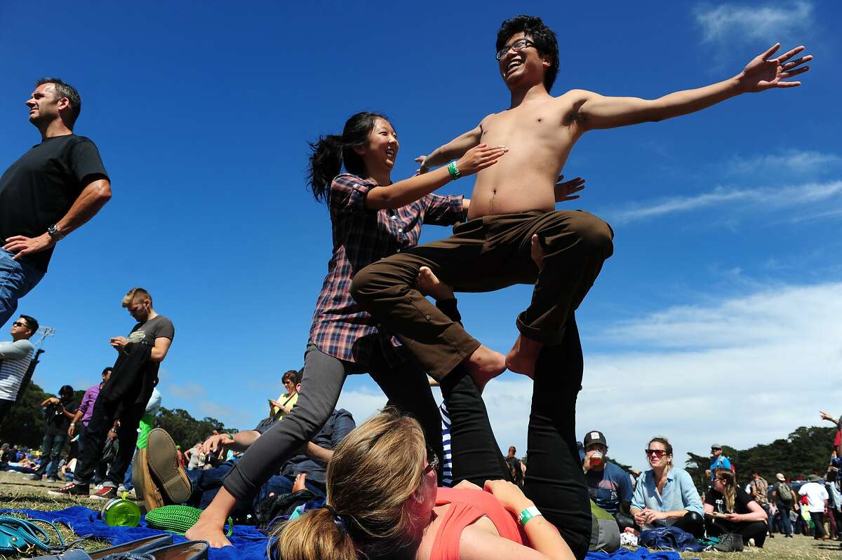 Hannah Yang helps balance Holman Gao as Amanda Bullington holds him up as they practice acro-yoga at Outside Lands Music Festival in Golden Gate Park on August 10, 2014 in San Francisco, CA.