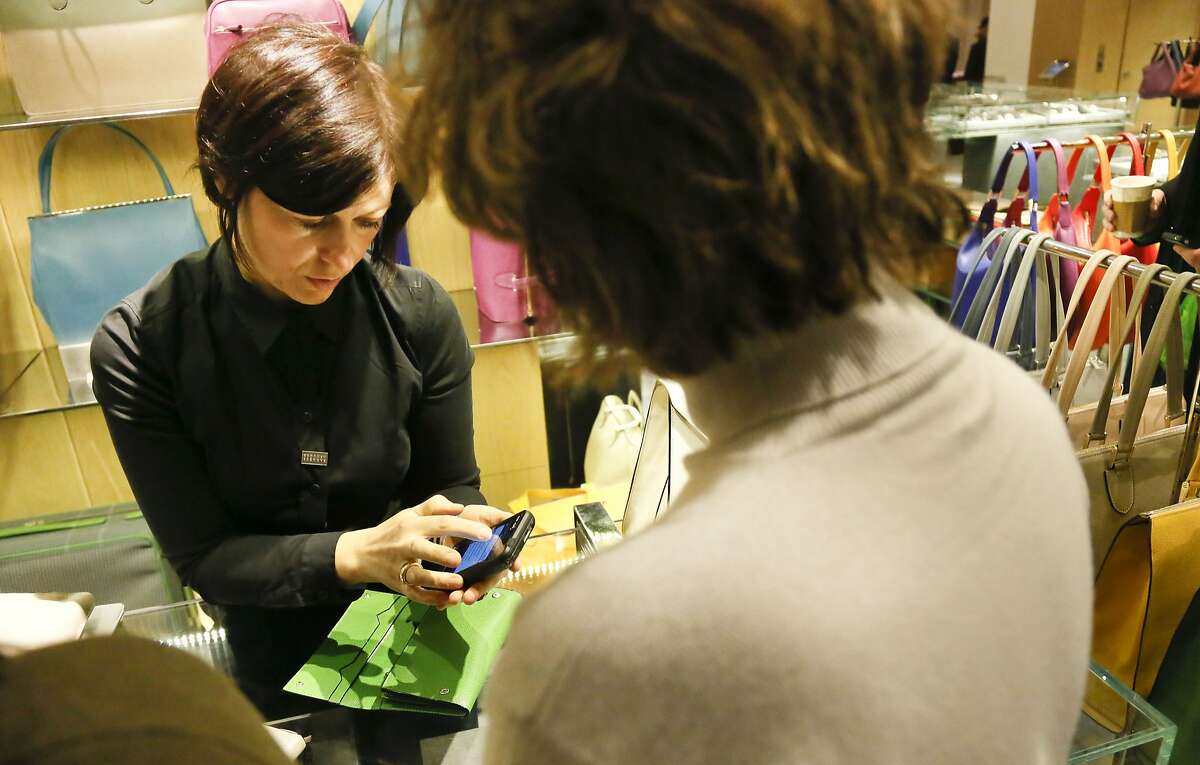 In this Friday, Feb. 15, 2013, photo, a sales staff member at Barney's New York uses an iPod Touch to help a customer make a purchase, in New York. Stores across the country are ditching the old-fashioned, clunky cash registers and instead having salespeople _ and shoppers themselves _ checkout on smartphones and tablet computers. (AP Photo/Bebeto Matthews)