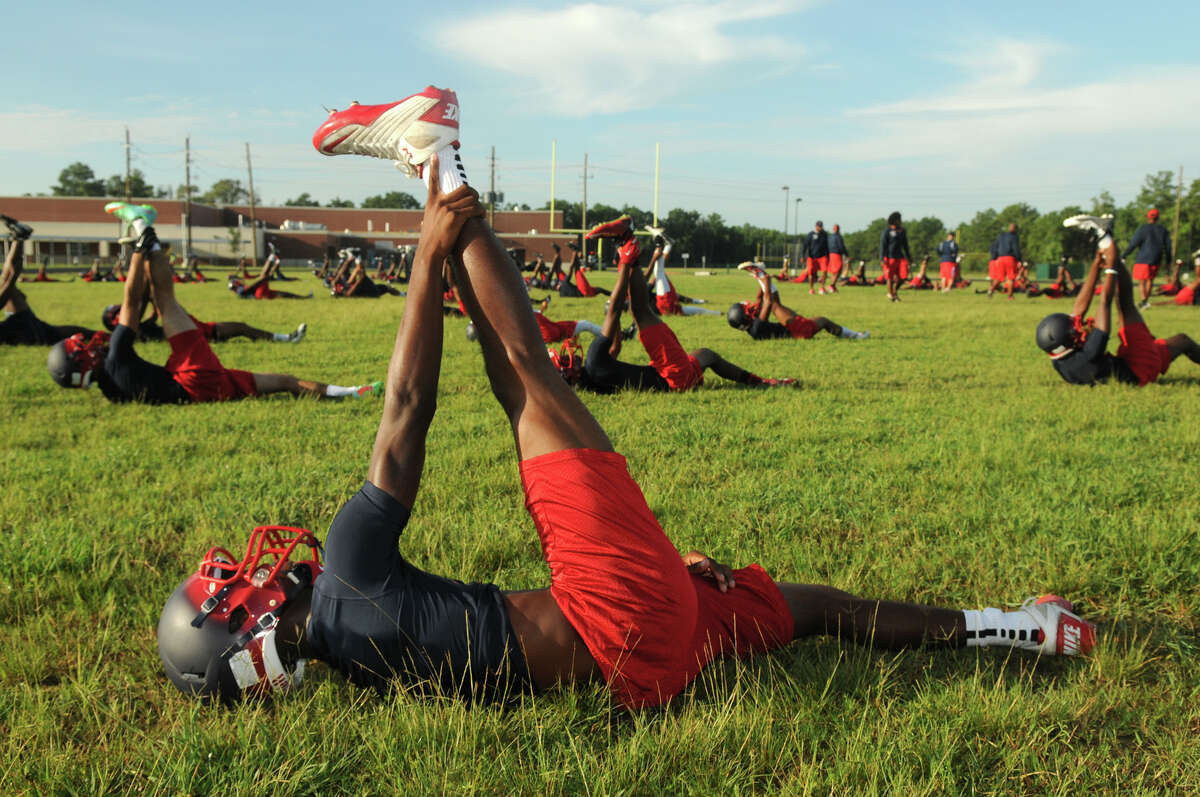 Aldine Davis senior defensive back Markus Allen and his teammates work through their warm-up calisthenics on the first day of practice for the school which is in its first year of varsity football this season.