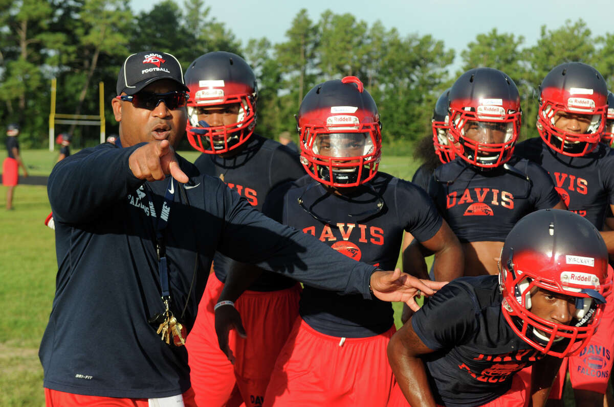 Aldine Davis Head Football Coach James Showers, left, pumps up his team on the first day of practice for the school which is in its first year of varsity football this season.