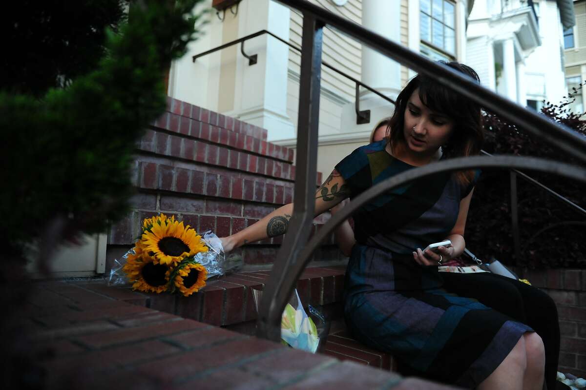 Caitlin Kerton adjusts her flowers after taking a picture with friend Samantha McMullen outside the Mrs. Doubtfire house on August 11, 2014 in San Francisco, CA. Robin Williams was found dead this morning in his Tiburon home.
