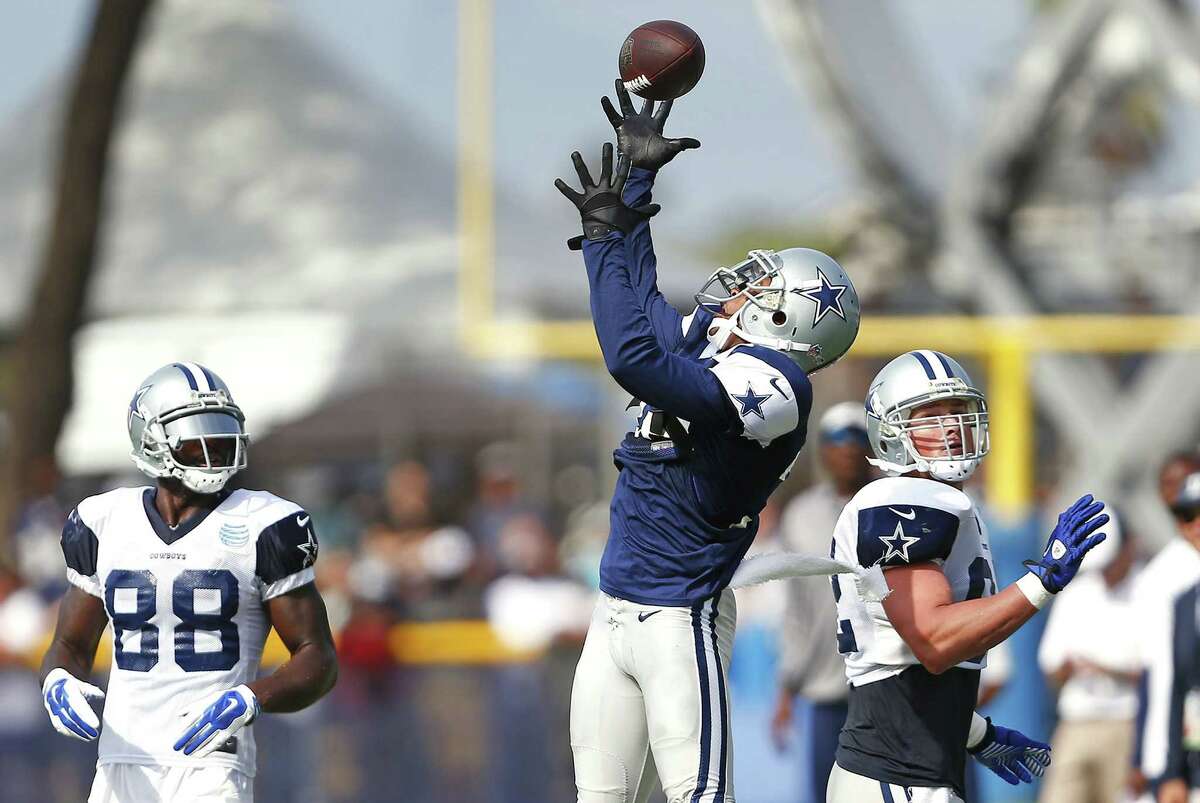 Dallas Cowboys cornerback Orlando Scandrick, middle, leaps to intercept a pass from Tony Romo, not pictured, in front of wide receiver Dez Bryant (88) and tight end Jason Witten, right, during the team's training camp on Sunday, Aug. 3, 2014, in Oxnard, Calif. (Ron Jenkins/Fort Worth Star-Telegram/MCT)