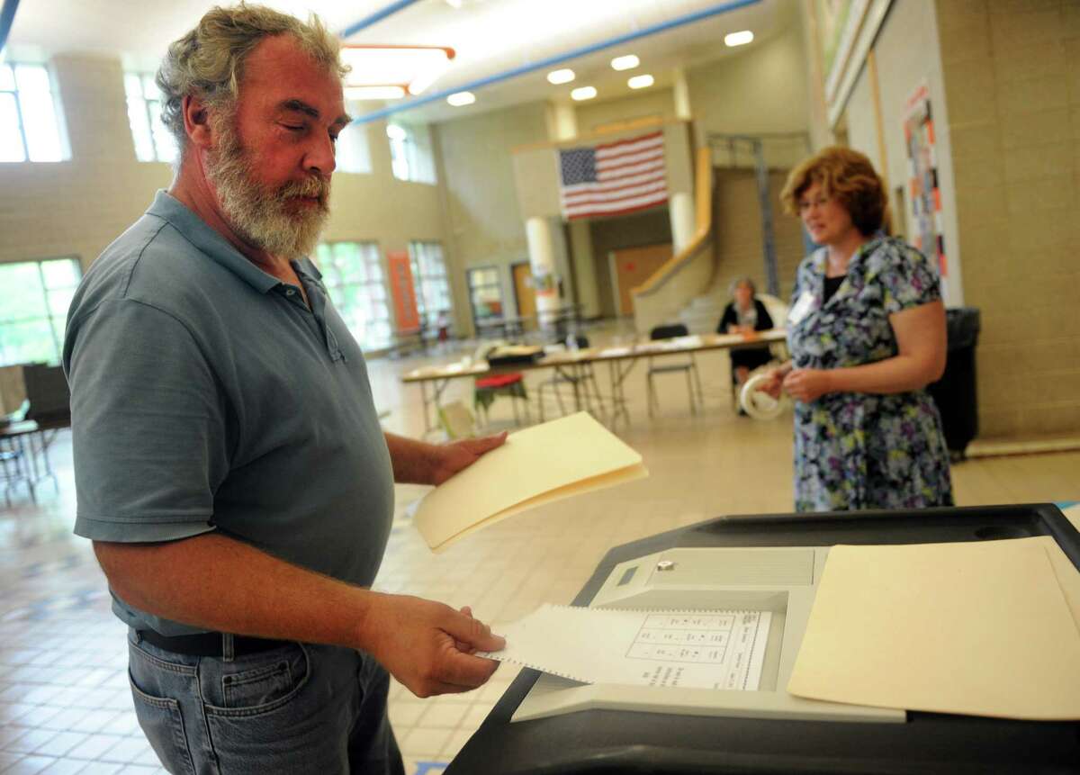 Dennis Welsh votes in the primary election Tuesday, Aug. 12, 2014 at Shelton Intermediate School in Shelton, Conn. Turnout is fairly low for the district with just 233 votes cast at 4:45 pm.