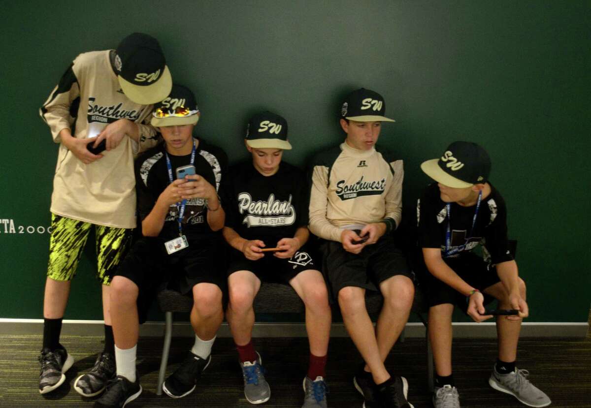 Players from Pearland Little League stop to check their phones during a tour of the World of Little League Museum in Williamsport, Pa on Tuesday, August 12, 2014. From left are, Michael Groover, Mathew Adams, Bryce Laird, Cole Smajstria and Landon Donley.