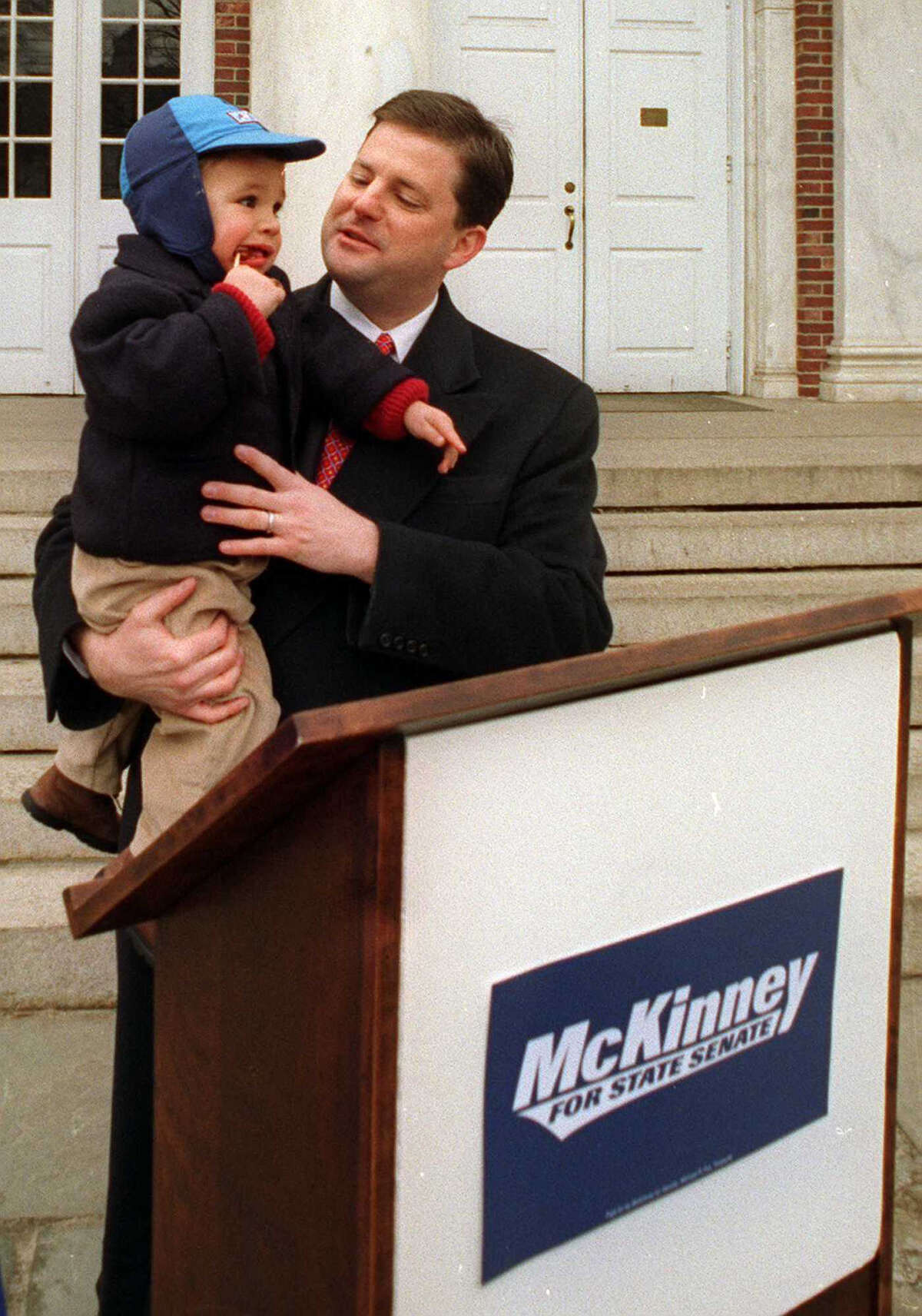 John McKinney holds his one year old son, Matthew, while announcing his candidacy for State Senate in Newtown, Conn. in 1998.