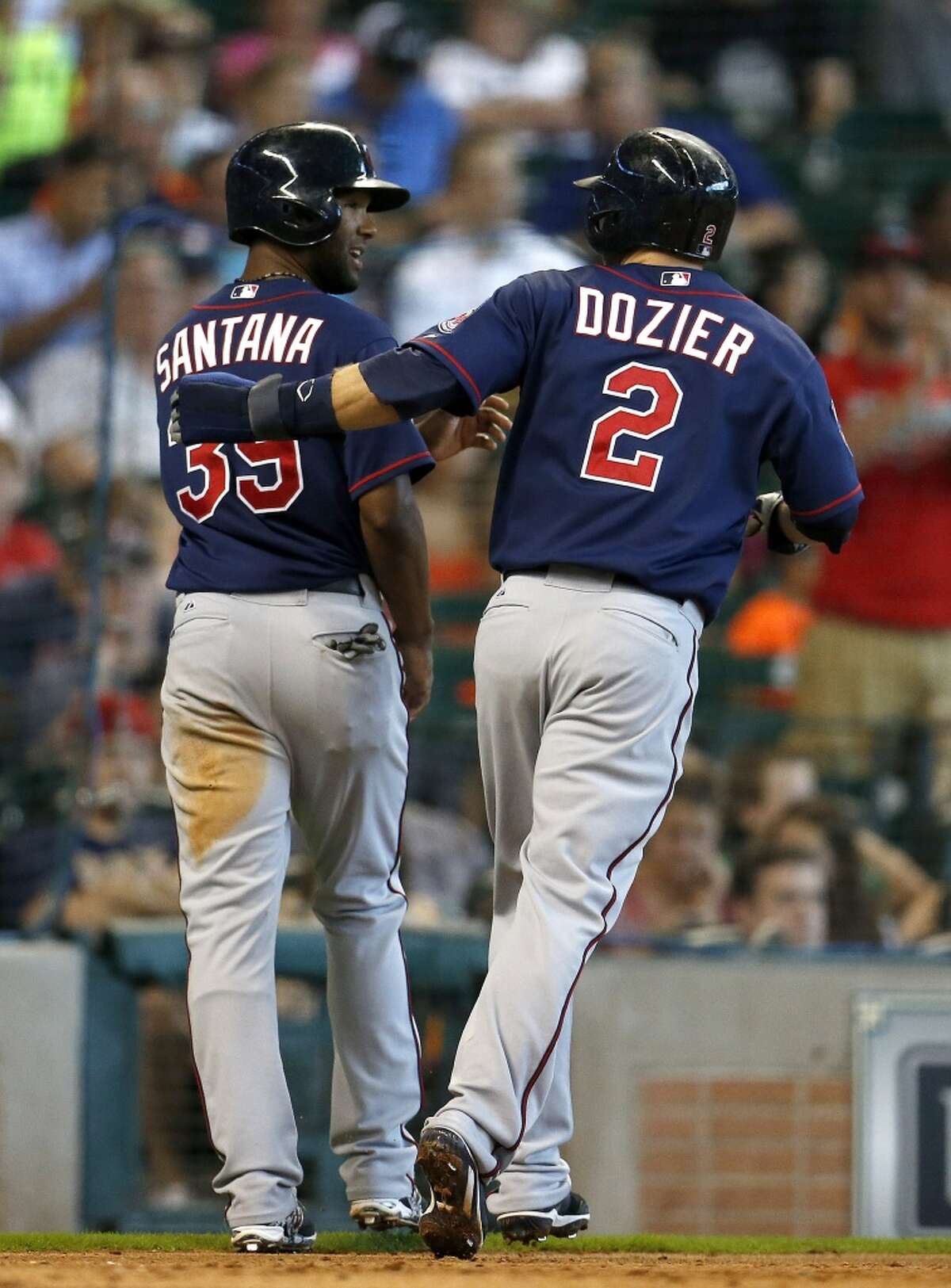 Twins second baseman Brian Dozier (2) and center fielder Danny Santana (39) celebrate after scoring runs on a single hit by first baseman Kennys Vargas during the eighth inning.