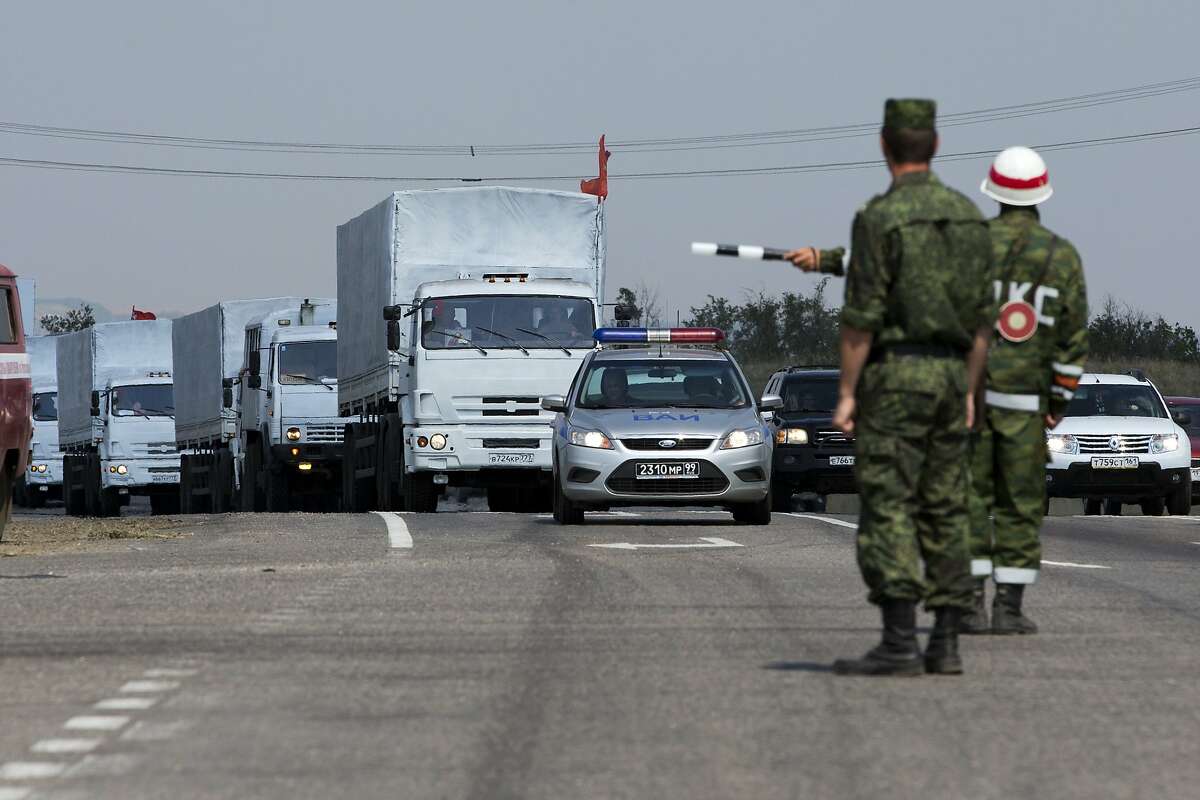 A convoy of white trucks with humanitarian aid is seen, about 28 kilometers from the the Ukrainian border, in Rostov-on-Don region, Russia, Thursday, Aug. 14, 2014. A large Russian aid convoy resumed its journey toward Ukraine Thursday, taking a road leading directly toward a border crossing controlled by pro-Russian rebels in the Luhansk region. By taking such a route, Russian appeared to be intent on not abiding by a tentative agreement to deliver aid to a government-controlled border checkpoint in the Kharkiv region, where it could more easily be inspected by Ukraine and the Red Cross. (AP Photo/Pavel Golovkin)