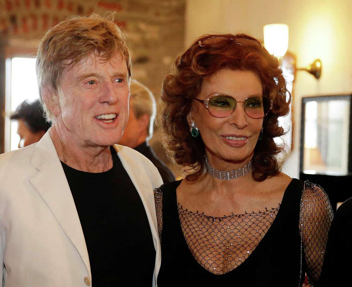 Robert Redford, left, and Sophia Loren pose for pictures before the start of “Bella Italia! a tribute to Sophia Loren" at the Far Niente winery Saturday, July 19, 2014, in Oakville, Calif. Loren turns 80 in September. The event is part of the Napa Valley Festival del Sole, a 10-day summer festival of music, theater and dance with the region’s wine and cuisine. (AP Photo/Eric Risberg)