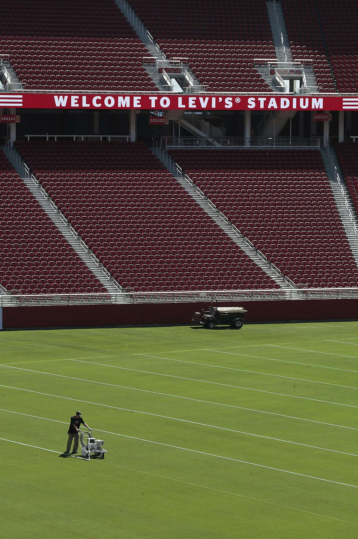 A crew member lines the field of the new Levi's Stadium on Thursday, Aug. 14, 2014 in Santa Clara, Calif. Views of the mountain range as well as rooftop flowers contribute to the stadium's feng shui.