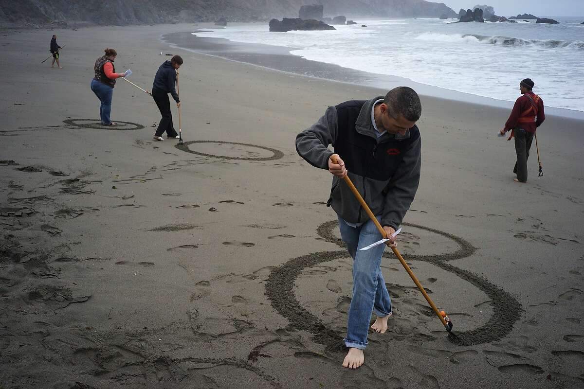 Jake Heath makes memorial art with friends and family of Lindsay Cutshall and her fiance on Friday, Aug. 14, 2014 in Jenner, Calif. Lindsay and her fiance were killed in Jenner ten years ago.