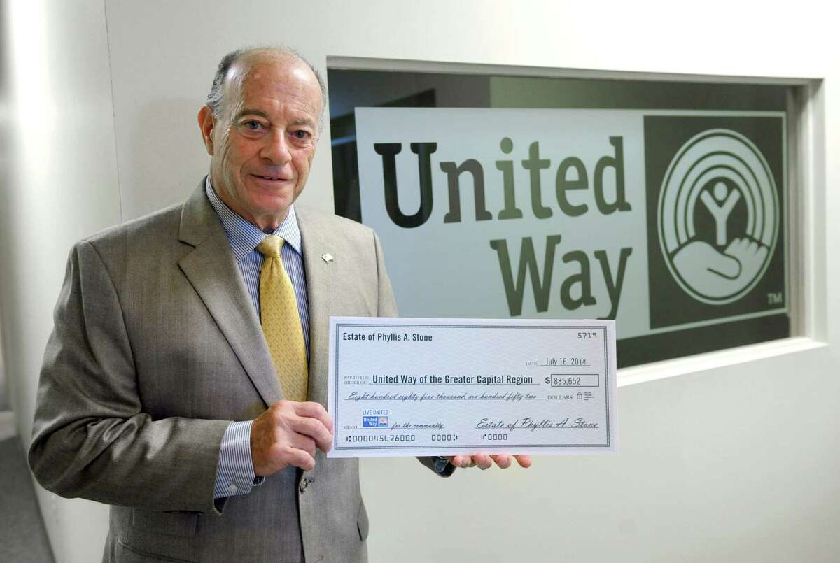 Immediate past board chair John Kearney holds a mock check of made out to the United Way of the Greater Capital Region from the estate of Phyllis Stone at the organization's office on Wednesday, Aug. 13, 2014 in Albany, N.Y. Phyllis Stone was a low-key and an unknown millionaire who died at 91 last year and gave $888,652 to the United Way of the Greater Capital Region, its largest gift ever. (Lori Van Buren / Times Union)