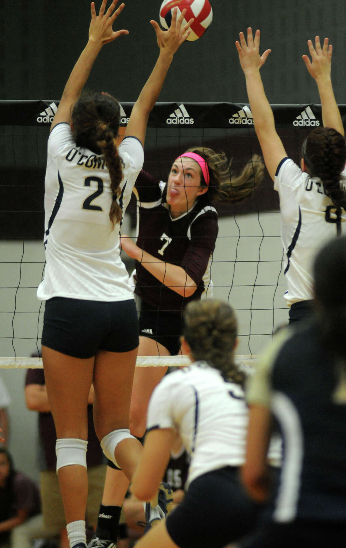 Pearland sophomore outside hitter Brooke Botkin, center, slams a ball between San Antonio O'Connor's Alex Ecker (#2) and Kaitlyn Kluna (#9) during their semifinal game at the 2014 Texas Volleyball Invitational at the Pearland High School Searcy Center on Saturday.