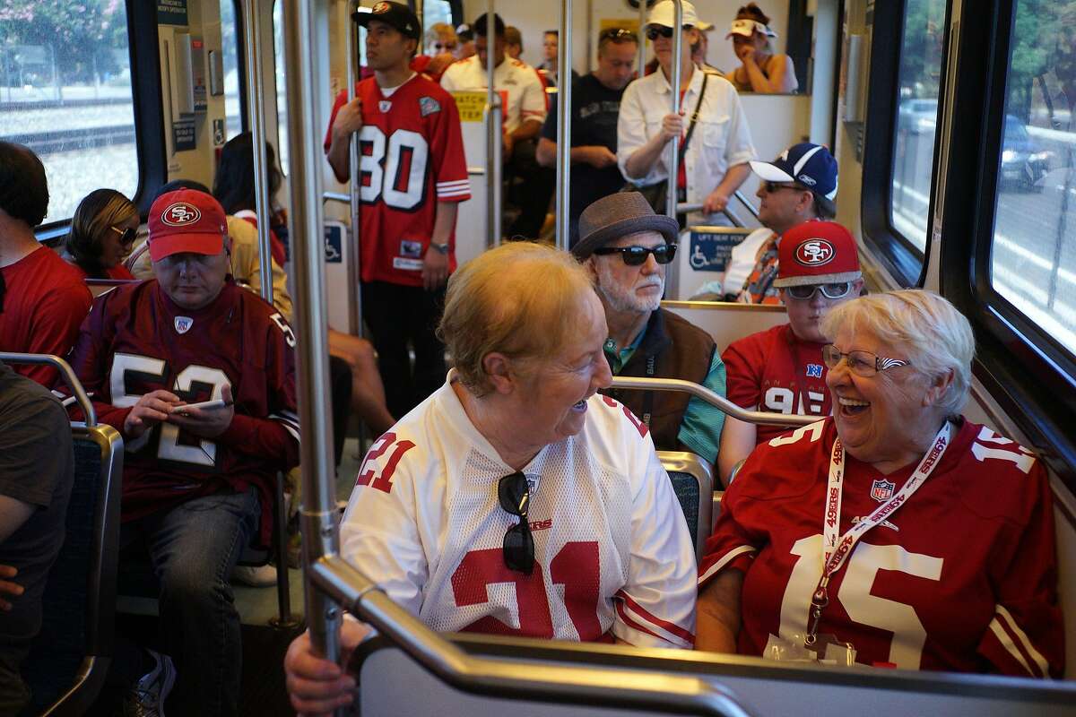 Mae Hendon, left, and Nathalie Pataky share a moment on the VTA Lightrail on Sunday, Aug. 16, 2014 in Santa Clara, Calif. 49ers fans came from all over the Bay Area to attend the first game at the Levi's Stadium.