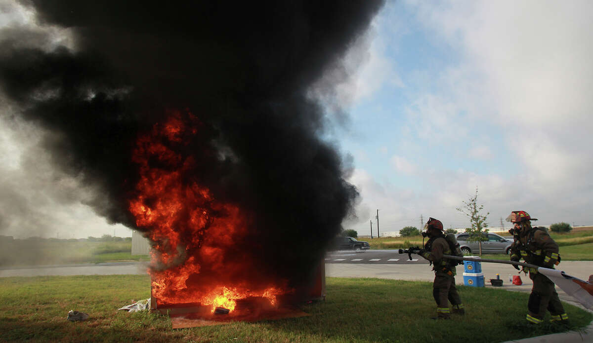 San Antonio firefighters extinguish a controlled fire set Wednesday July 30, 2014 at the San Antonio Fire Training Academy. The Houston Field Division of the Bureau of Alcohol, Tobacco, Firearms and Explosives (ATF) held a three-day training program for prosecutors to help them understand the fire investigation process. The program is designed to help prosecutors understand fire dynamics and the scientific methodology used to solve challenges presented by the crime of arson.