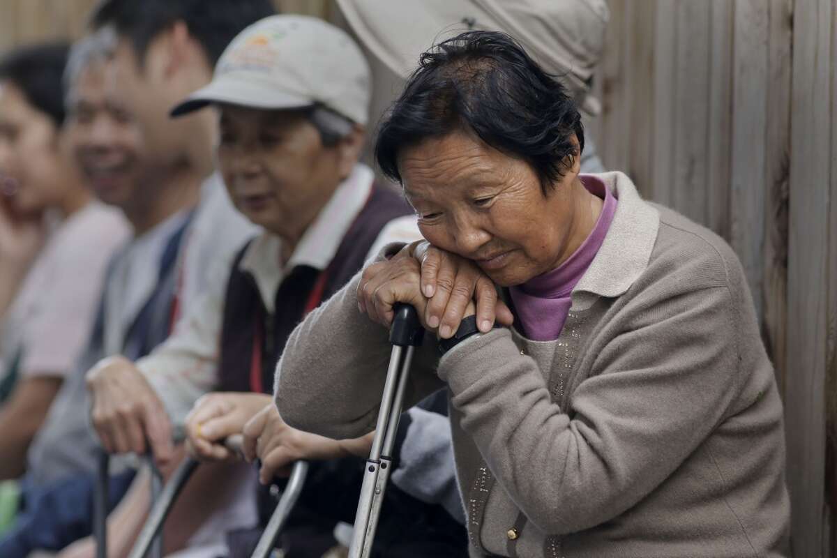 In this file photo, Zeng Yua Ma waits along with others for the food pantry distribution at South Hayward Parish, on Wednesday April 16, 2014, in Hayward, Calif.