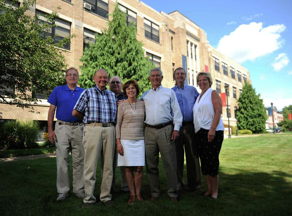 Danbury High School class of 1964 members, from left, Michael Stein, of Danbury, Alan Mattei, of Southbury, Ted Lucas, of Danbury, Shirley and Terry Rodrigues, of Brookfield, Vin Iovino, of Southbury, and Phyllis Scarpone, of New Milford, pose outside of Western Connecticut State University's White Hall in Danbury, Conn. Monday, Aug. 18, 2014. White Hall used to be Danbury High School and the class of 1964 was the final graduating class from there.