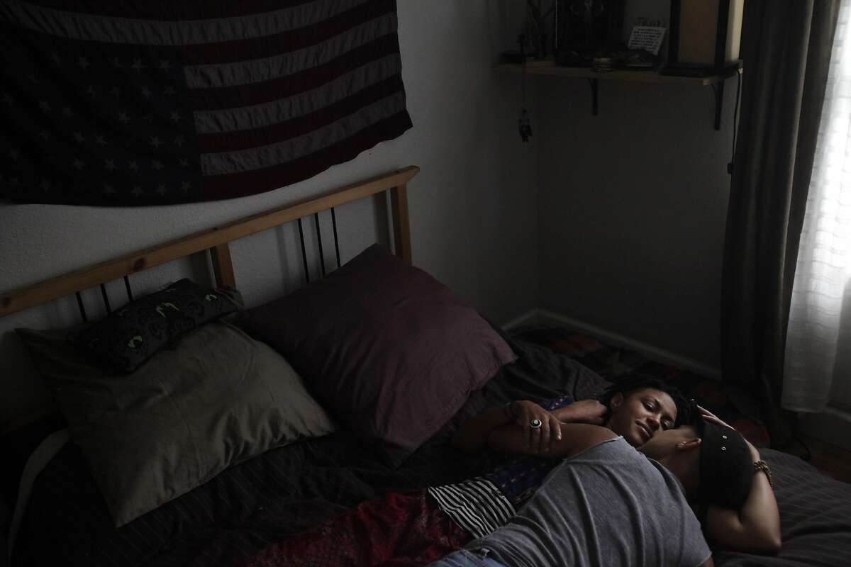 Partners Barbara Jefferson, 29, left, and Sonj Basha, 26, lay in their bed together after dinner August 7, 2014 at their home in Oakland, Calif. Basha, who identifies as gender queer, was part of the Gender Identity and Expression Committee that developed a new policy for Mills College on the inclusion of transgender and gender fluid students at the school. Jefferson identifies as gender neutral.