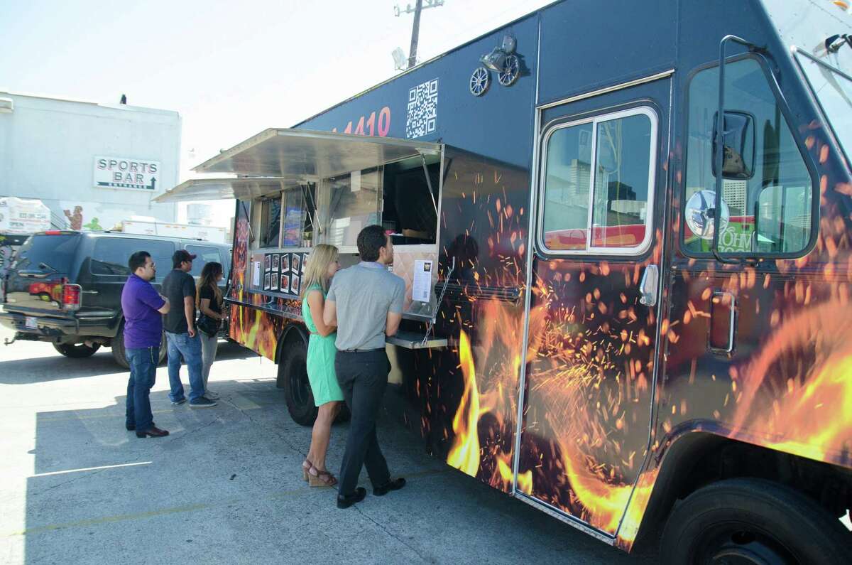 Customers line up during lunch at Reign Food Truck at Houston Food Park near downtown.