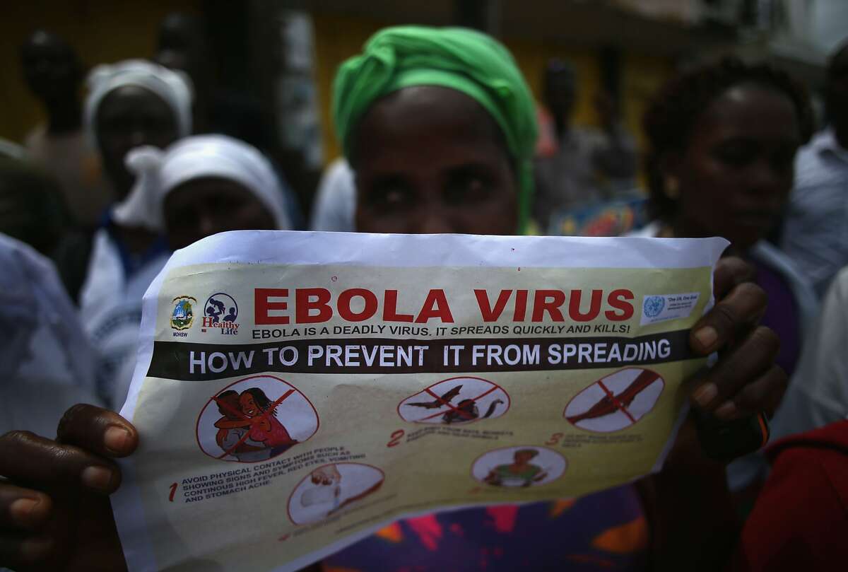 Public health advocates stage street theater to attract people to attend an Ebola awareness and prevention event on August 18, 2014 in Monrovia, Liberia.
