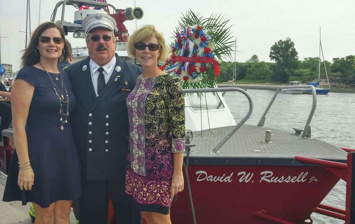 From left, Terese Flaherty, David W. Russell, III, and Eleanor Macfarlane, in front of the new fire boat named in honor of their father, former Fire Chief David W. Russell, Jr.