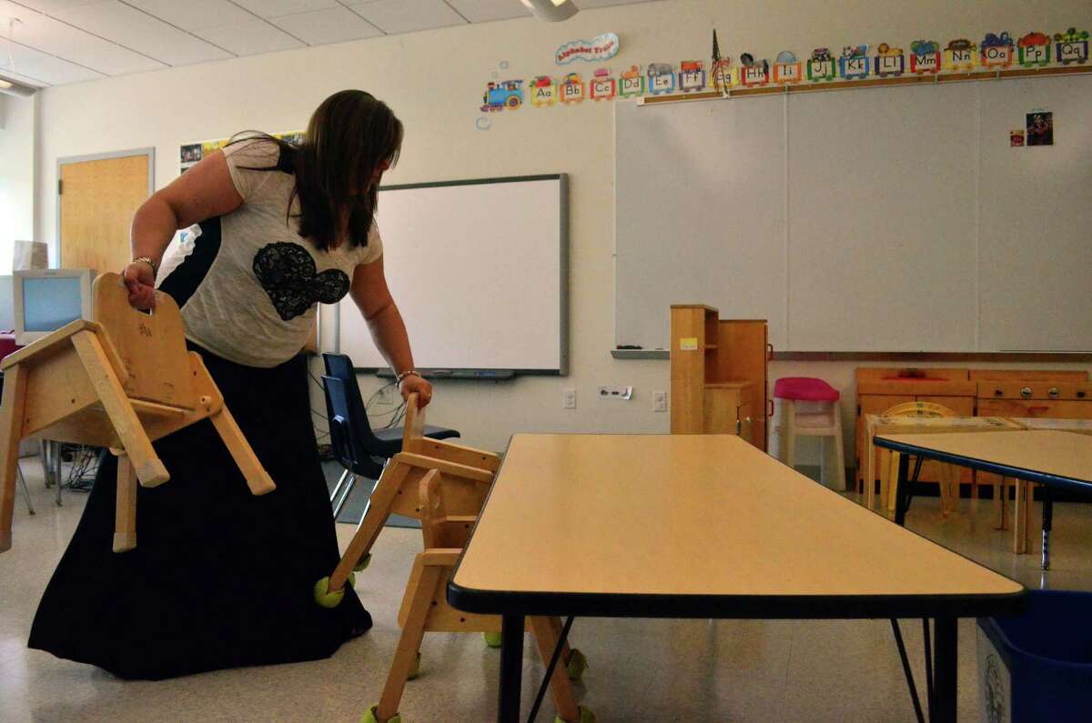 Tokeneke Elementary School pre-kindergarten teacher Kristin I'Orio sets out chairs in a classroom in the week before students start the 2014-15 school year.