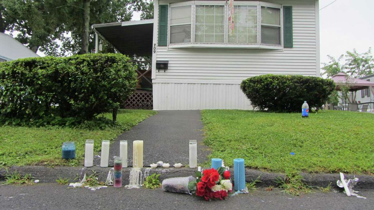 People mourning the deaths of Michael Allen and Maria Lockrow left candles and flowers outside the home where they were beaten to death early Wednesday morning. So far, no arrests have been made and police are still searching for a 2013 Ford Escape that was taken from the house after the attack. (Bob Gardinier / Times Union)