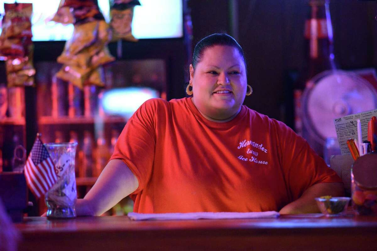 Bartender Michelle Hernandez smiles at a customer at Hernandez Ice House on West Mitchell on Saturday, Aug. 16, 2014.