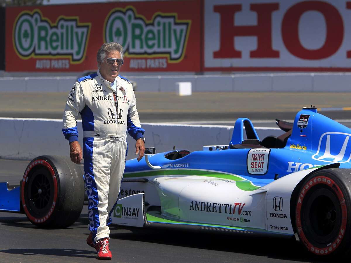 Mario Andretti walks past his two-seater Indy car before driving Chronicle sports writer Tom FitzGerald on a lap around the Sonoma Raceway track in Sonoma, Calif. on Thursday, Aug. 21 2014. The GoPro Grand Prix of Sonoma is this Sunday.