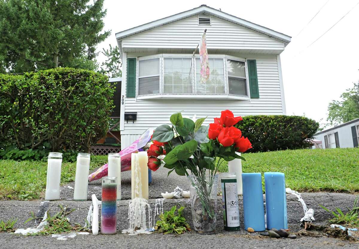 People mourning the deaths of Michael Allen and Marie Lockrow left candles and flowers overnight outside the home Thursday, Aug. 21, 2014, where they were beaten to death early Wednesday morning at at 709 1st Ave. in Troy, N.Y. (Lori Van Buren / Times Union)