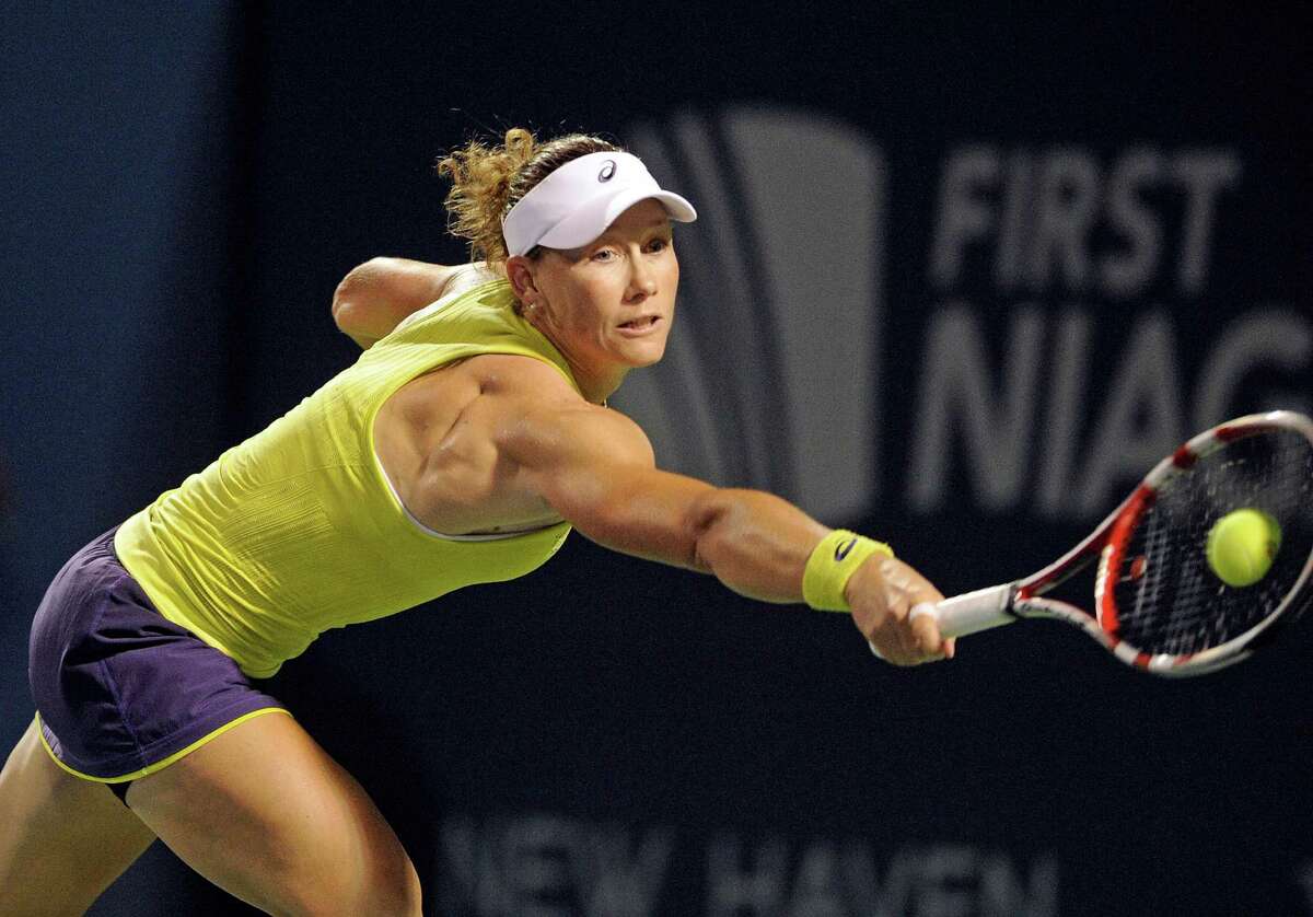 Samantha Stosur, of Australia, reaches for a backhand during her 6-3, 4-6, 6-3, victory over Kirsten Flipkens, of Belgium, in a quarterfinal match at the New Haven Open tennis tournament in New Haven, Conn., on Thursday, Aug. 21, 2014. (AP Photo/Fred Beckham)