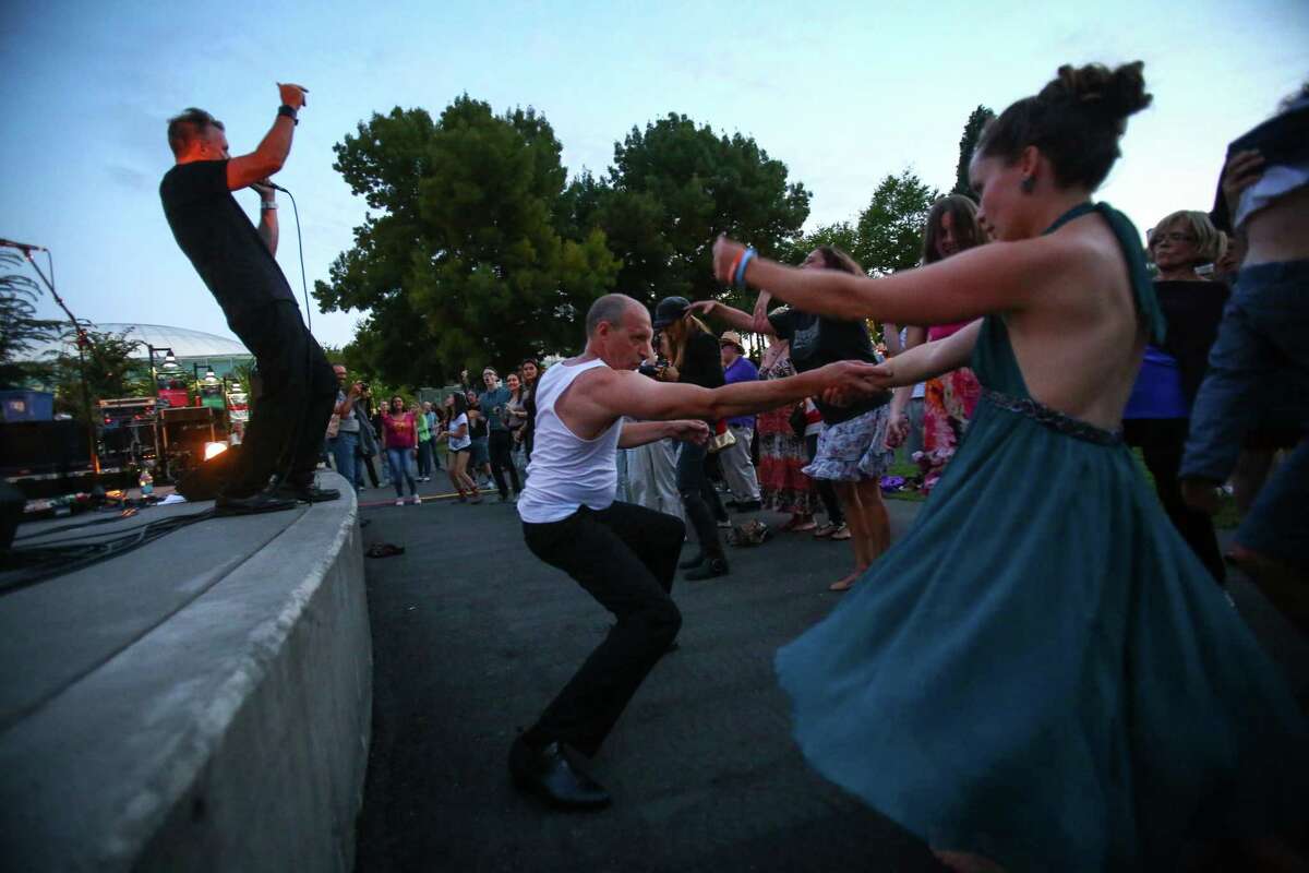 People dance as The Beatles cover band Creme Tangerine performs at Seattle Center's Mural Amphitheater on Thursday.