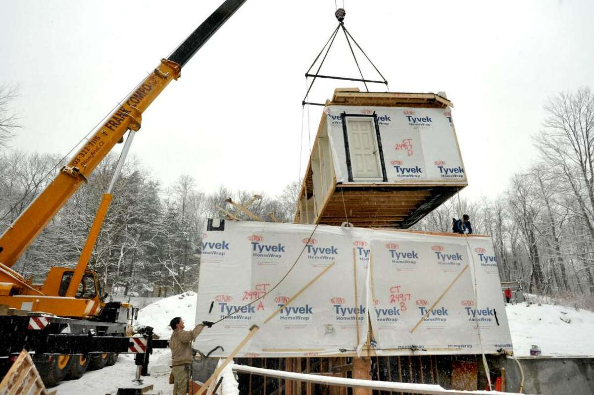 Builder Kevin Coyle, 46, guides the second level of the new modular home as it is lifted, at the construction site in Redding, on Tuesday, Feb.16,2010.