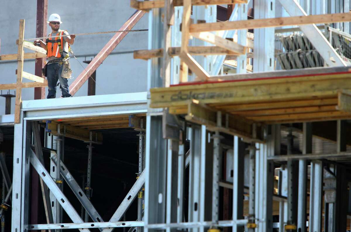A construction worker helps build The Susanne, a luxury apartment complex in the Montrose neighborhood, on Wednesday, Aug. 13, 2014, in Houston. ( Mayra Beltran / Houston Chronicle )
