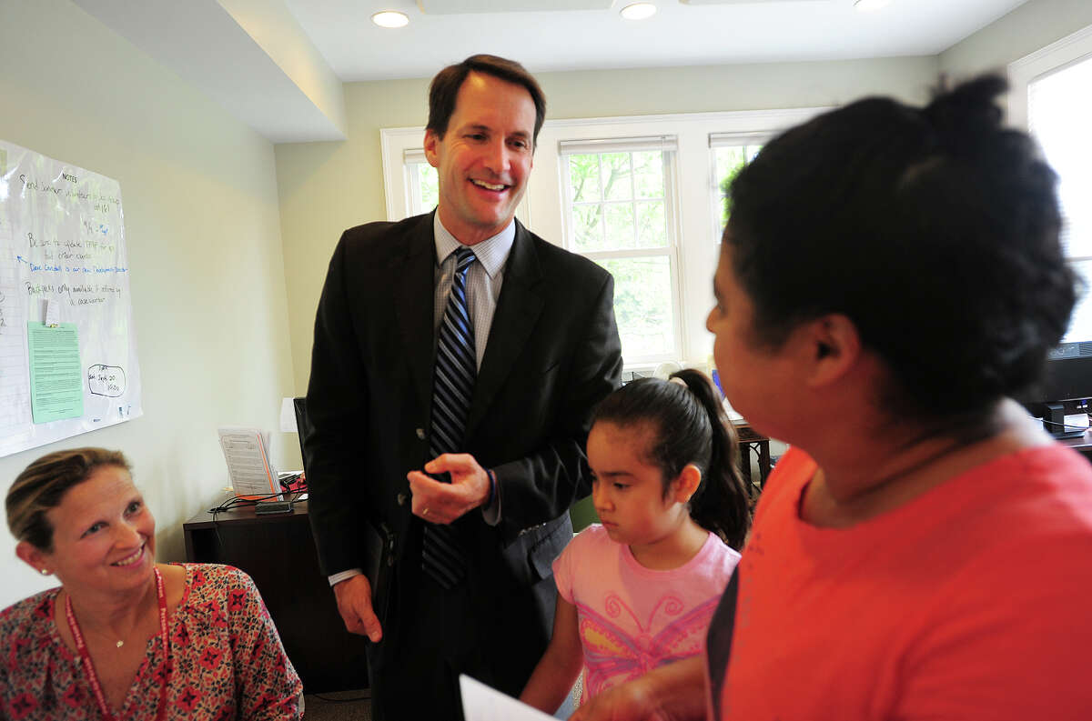 Congressman Jim Himes speaks Spanish with Rosa Raimundo and her granddaughter Ashlie Barrios, 8, both of Stamford, during a visit to Person to Person in Darien, Conn. on Thursday, August 21, 2014. At left is volunteer Liz Mackie, of Darien. The stop was part of Himes' 17 Towns in 17 Days Tour, visiting all 17 towns in the 4th Congressional District where he is running for re-election this year.