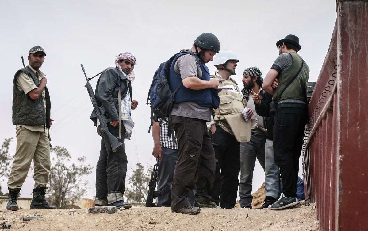 American journalist Steven Sotloff (center, in black helmet) talks to Libyan rebels in this 2011 photo.