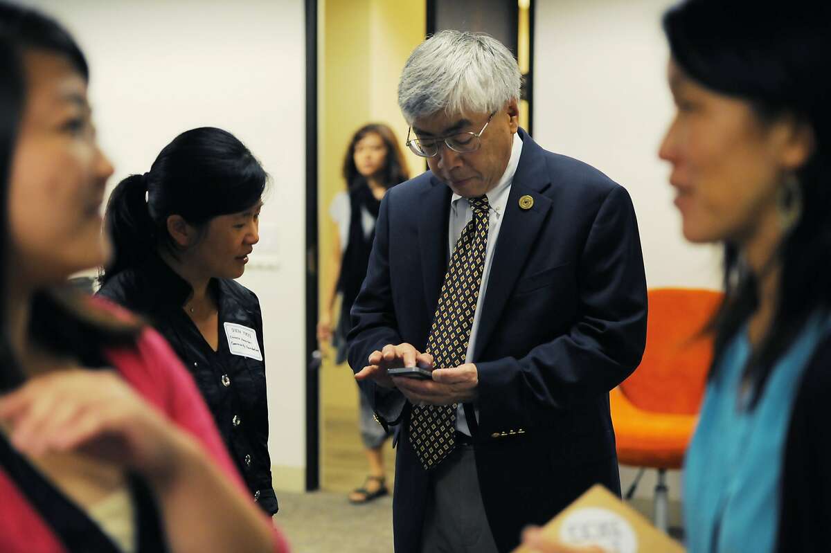 Buck Gee shows photos on his phone to Dien Yuen during a business event on August 19, 2014 in San Francisco, CA. Buck Gee is a former Cisco VP who is now leading a charge to show the lack of Asians in leadership positions in tech.