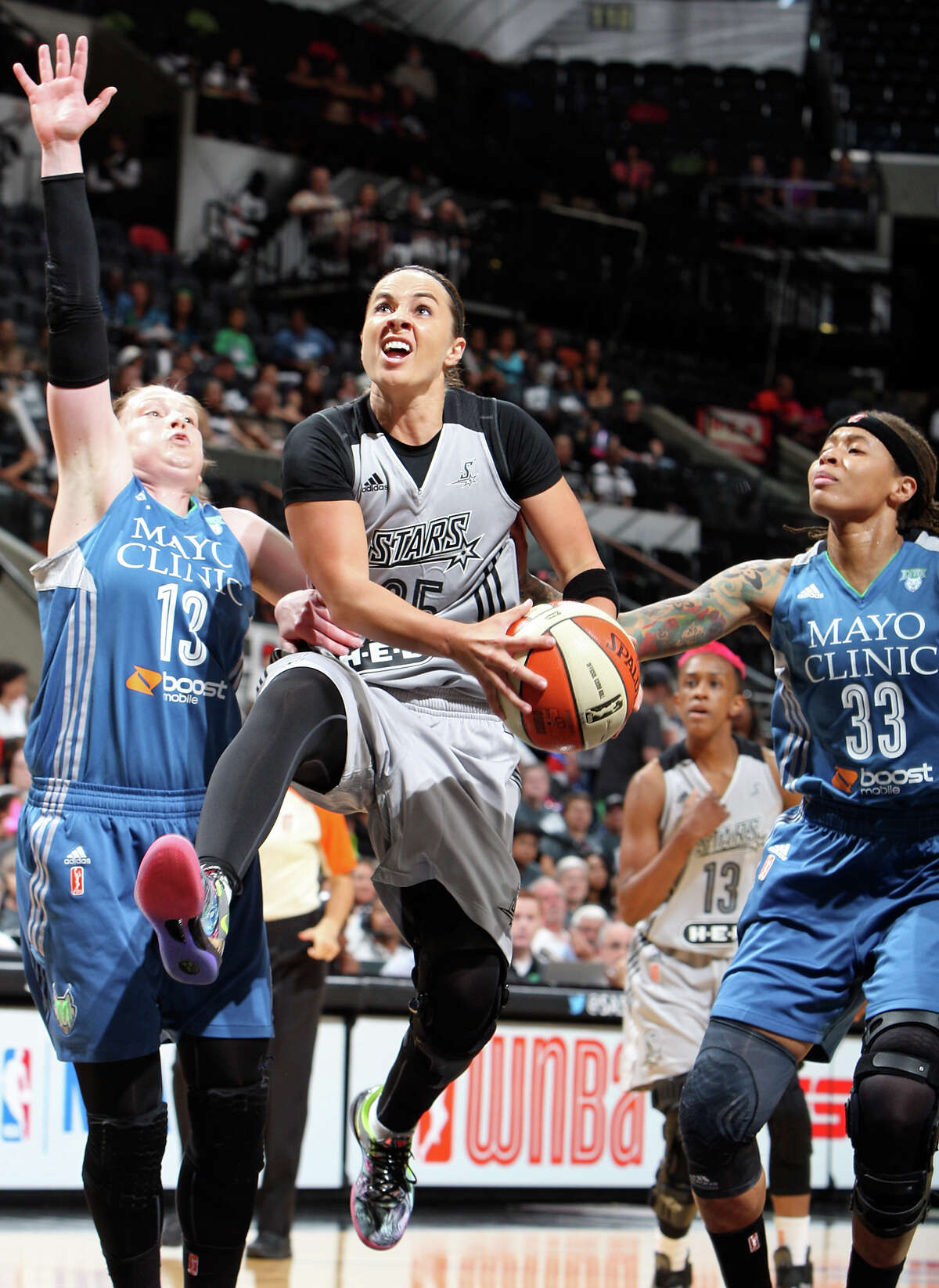 San Antonio Stars' Becky Hammon drives to the basket between Minnesota Lynx's Lindsay Whalen (left) and Seimone Augustus during first half action Saturday Aug. 23, 2014 at the AT&T Center.