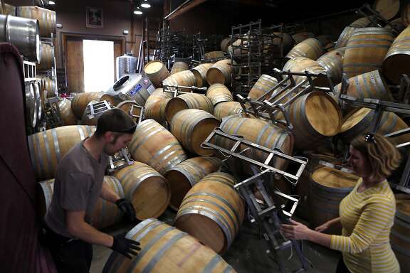 Saintsbury Winery's Ry Richards (left) and Chris Kajani work on removing the stacks of empty barrels that tumbled over after an earthquake in Napa, Calif. on Sunday, August 24, 2014,